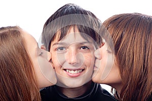 Two pretty girls kissing smiling boy