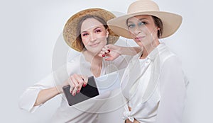 Two pretty girls posing against a white background before going on a trip. Tourism concept