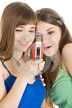 Two pretty girls reading SMS on mobile phone