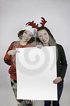 Two pretty women holding sign for copy space