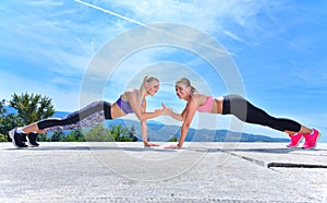 Two pretty women stretching in a park before starting a workout session