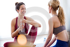 Two pretty young sporty women relaxing after yoga session at home.