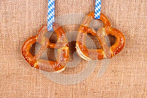 Two pretzel in heart shape on jute background