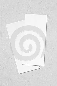 Two price-list or menu mockups lying diagonally on top of each other on grey concrete background