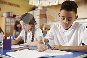 Two primary school pupils at their desks in class, close up