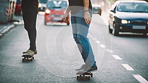 Two pro skateboard rider ride skate through cars on street