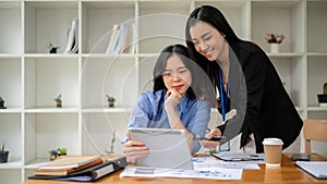 Two professional Asian businesswomen are discussing work. Teamwork concept