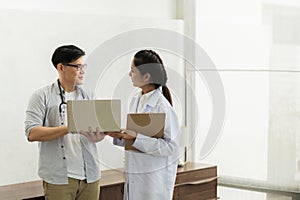 Two professional asian man and woman doctor discussing on laptop to analyse patient person