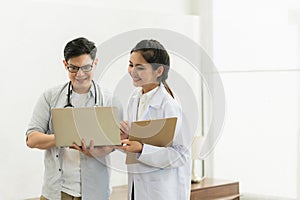 Two professional asian man and woman doctor discussing on laptop to analyse patient person