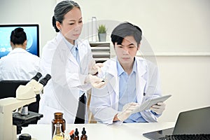 Two professional Asian scientists working together in the lab