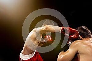 Two professional boxer boxing on black background,