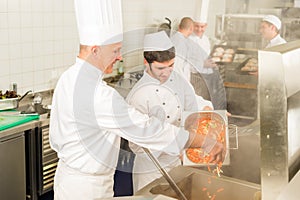 Two professional chefs cooking in kitchen