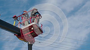 Two professional electricians from cab of aerial platform are repairing street lighting lamp. Video of two electricians