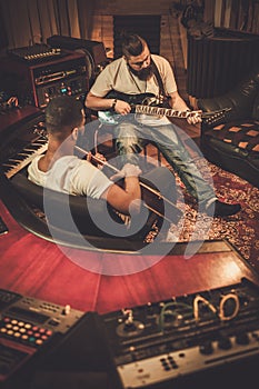 Two professional guitarists performing in boutique recording studio