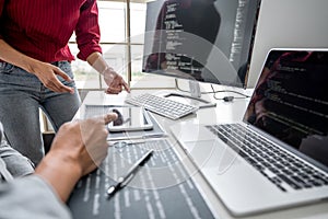 Two professional programmer cooperating and working on web site project in a software developing on desktop computer at company,