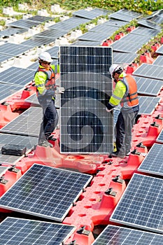 Two professional technician workers stand and hold solar cell panel to check and maintenance the system in concept of green energy