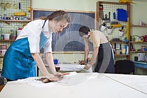 Two Professional Workers Preparing a Clay Pieces on Tables in Workshop