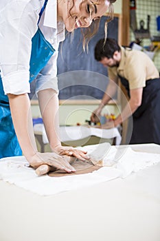 Two Professional Workers Preparing a Clay Pieces on Tables in Workshop