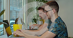 Two IT programmers are working on computer in a modern office room. Web developers working at the computer.
