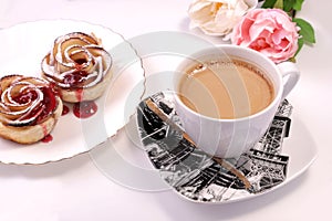 Two puff pastry cakes on a table with a cup of coffee
