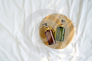 Two pump bottles, one brown and one green, contain soap, lotion, or some other liquid product for personal care or cleaning placed