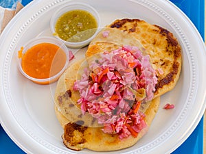 Two Pupusas with Two sauces on a plate