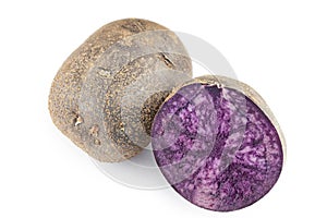 Two purple potatoes, one cut, the other whole. Isolated on white background