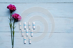 Two purple roses with tampons on the table