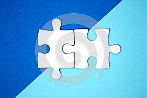 Two puzzle pieces connect on blue geometry color paper