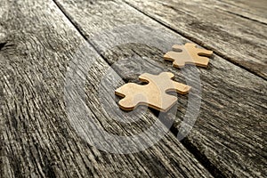 Two puzzle pieces lying on wooden rustic boards