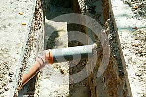 Two pvc sewer pipe connected underground in the trench on the street.