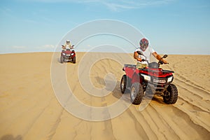 Two racers coming down from the dunes on atv