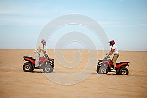 Two racers in helmets stand face to face on atvs