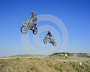 Two racers jumping in the air during motocros competition