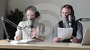 Two radio presenters man and woman host broadcast podcast Spbi. Man read speech from paper