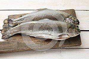 Two rainbow trouts on rustic wooden table