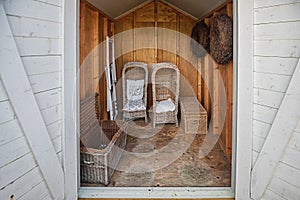 Two rattan garden chairs and rattan baskets stowed in the shed