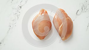 Two raw chicken breast on white backdrop