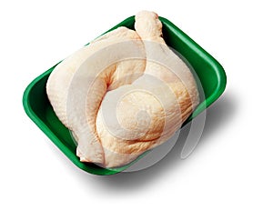 Two raw chicken legs in a green tray over white background