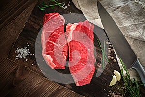 Two raw chuck steak on a wooden Board