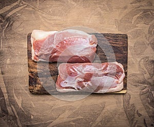 Two raw duck breast on a cutting board on wooden rustic background top view close u