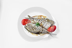 Two raw fish on a white plate