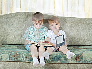 Two reading boys. With paper and electronic book