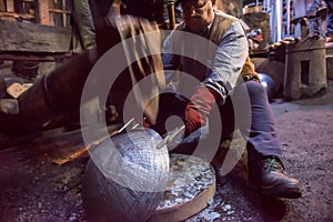 Blacksmith workers using mechanical hammer at workshop