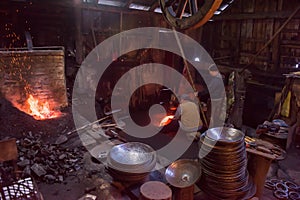 Blacksmith workers using mechanical hammer at workshop