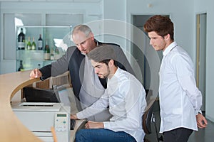 Two receptionist workers and manager standing at hotel counter