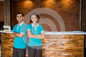 two receptionists standing with hands crossed against reception desk background