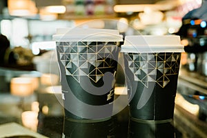 Two recycled cardboard cups with lids, hot coffee to go