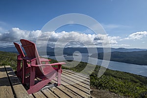 Two Red Adirondack Chairs With a Grand Vista  1