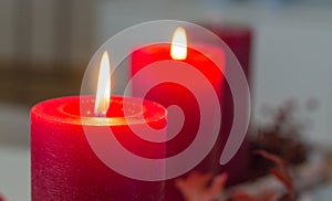 Two red advent candles are buring brightly on a modern advent wreath.